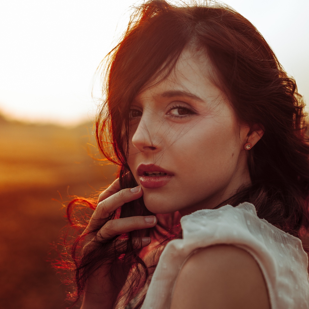 Ветер развивает волосы молодой девушки 