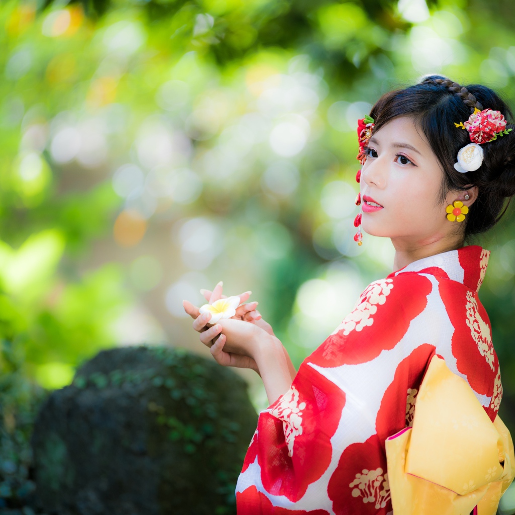 Молодая девушка азиатка в кимоно с цветами в волосах 