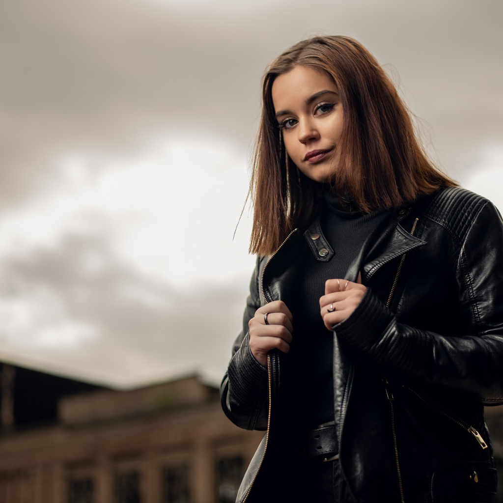 Молодая девушка в кожаной куртке на фоне грозового неба