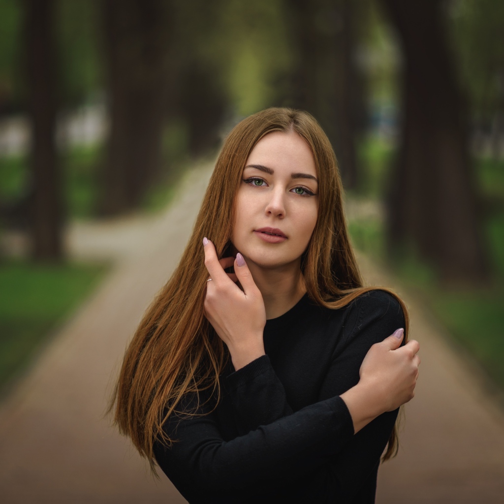 Молодая девушка в черном наряде в парке