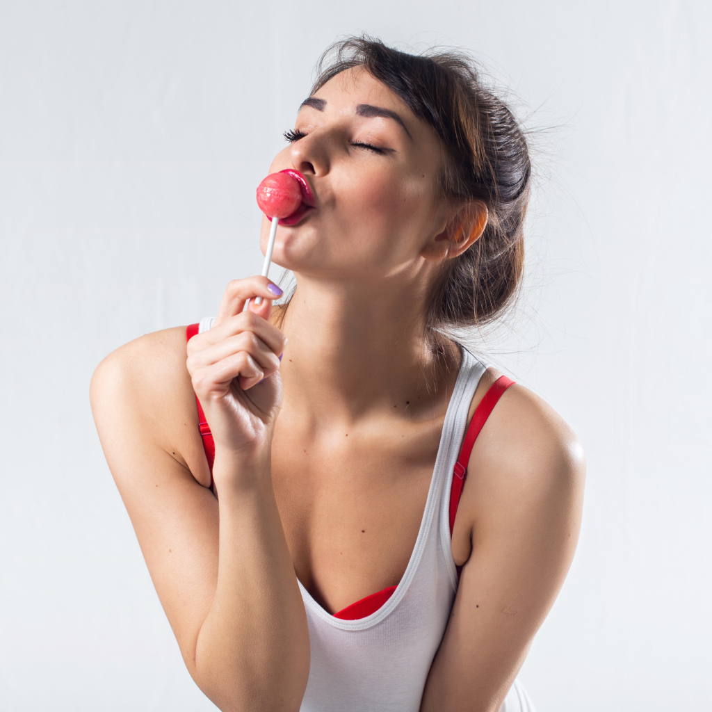 Молодая девушка с конфетой на палочке