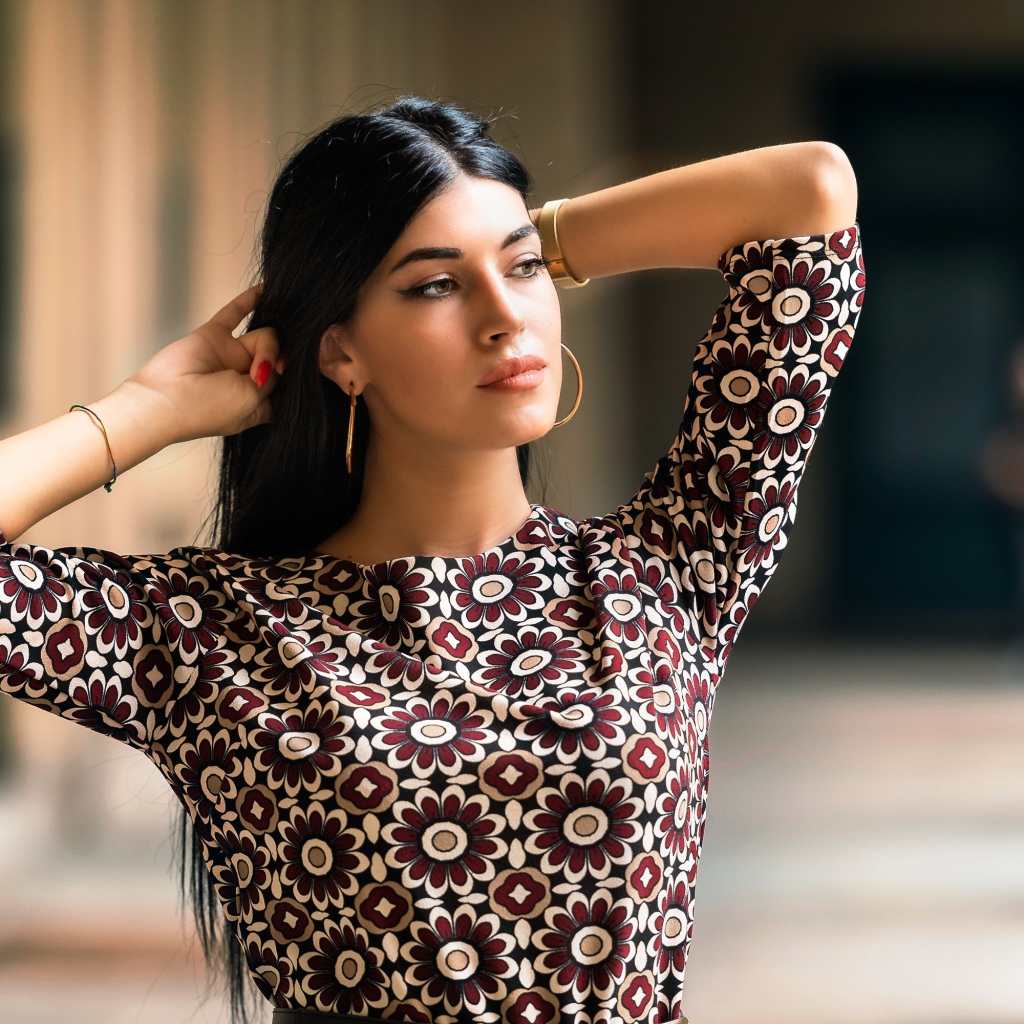 Молодая длинноволосая шатенка с руками в волосах