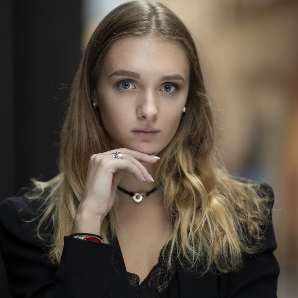 Молодая нежная голубоглазая девушка с рукой у лица