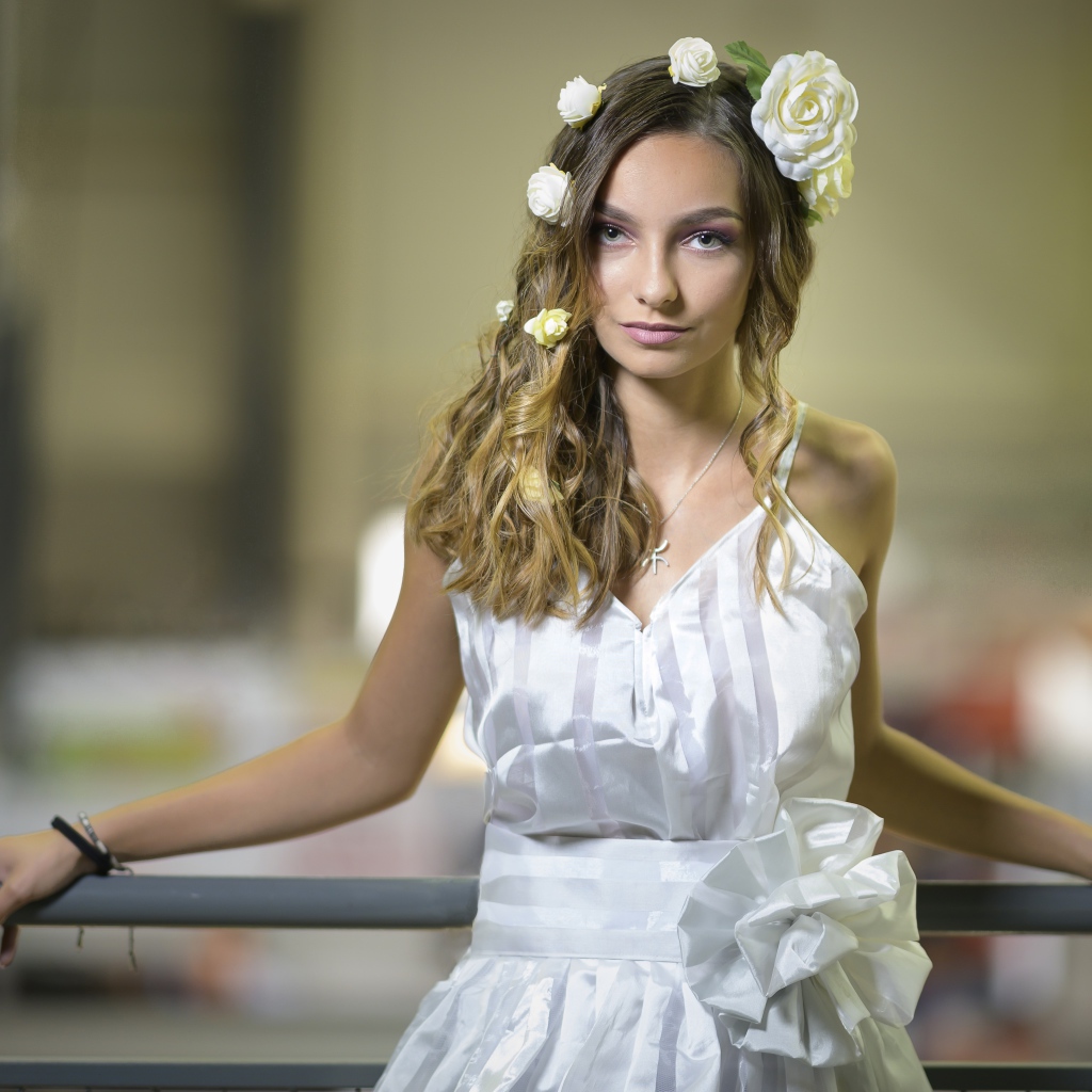 Красивая девушка в белом платье с цветами в волосах 