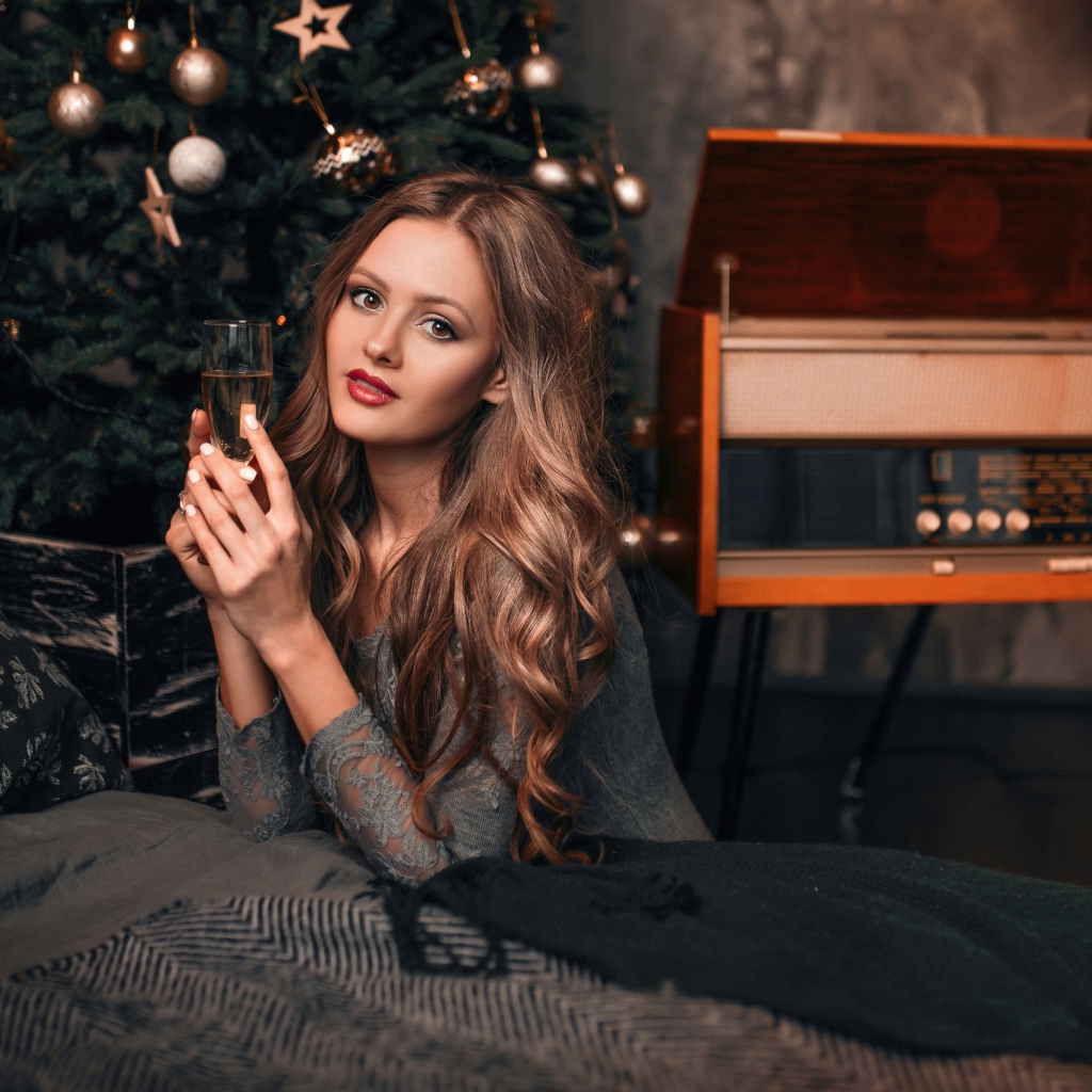 Красивая девушка с фужером шампанского у новогодней елки