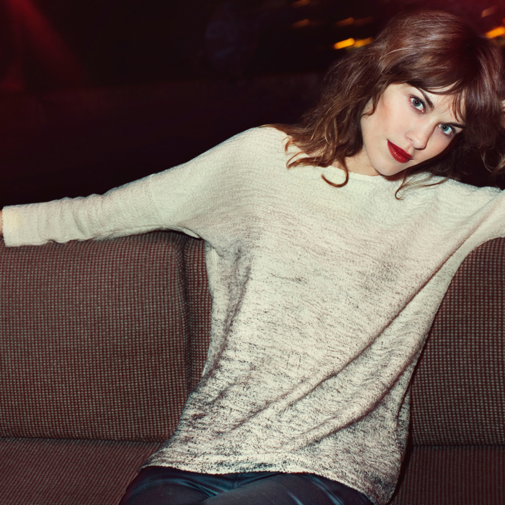 Красивая девушка модель Алекса Чанг сидит на диване