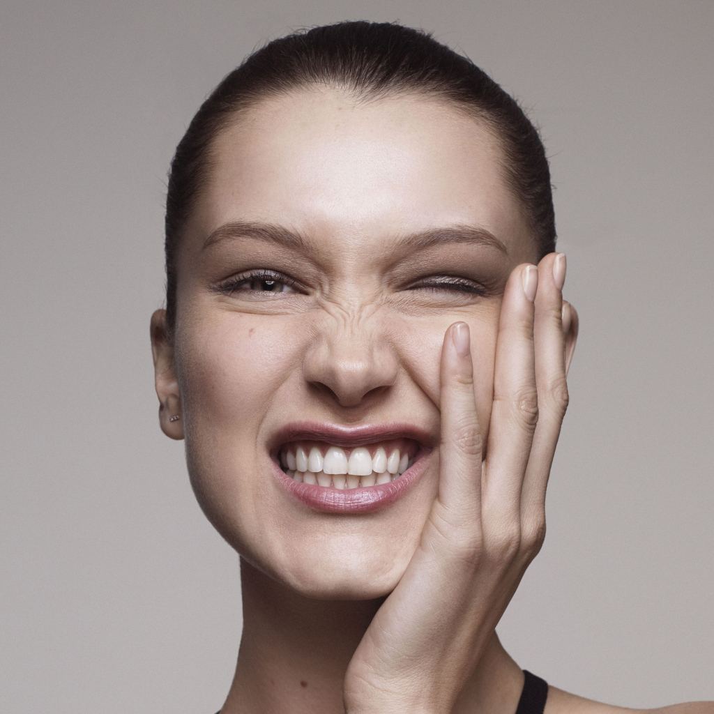 Модель Белла Хадид корчит гримасы на сером фоне