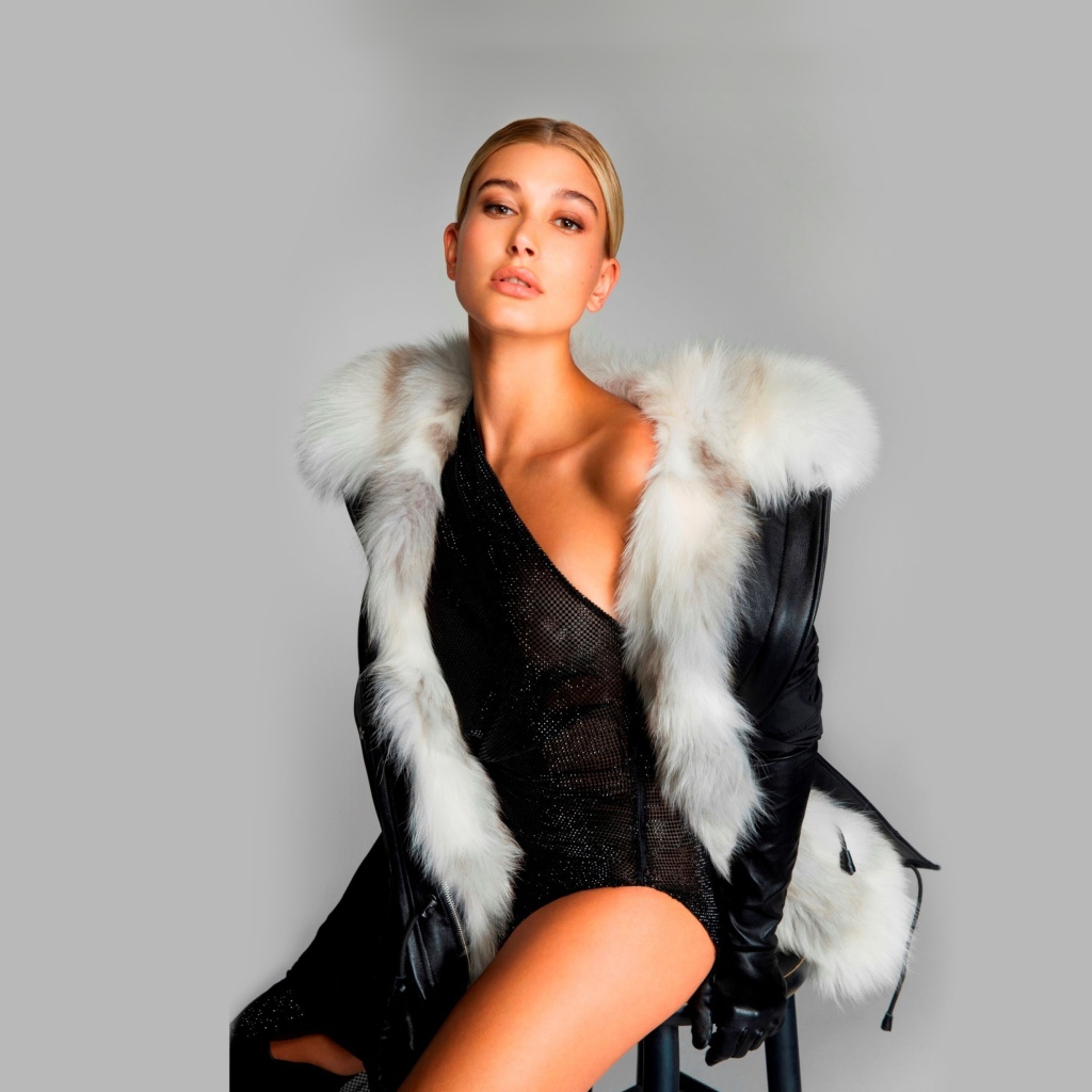 Эффектная модель Хейли Болдуин сидит на стуле на сером фоне