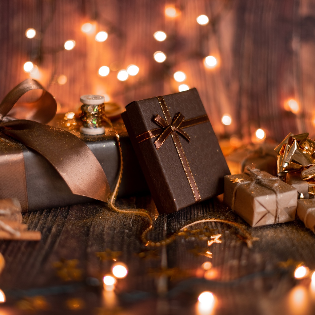 Много подарков на деревянном фоне с гирляндой