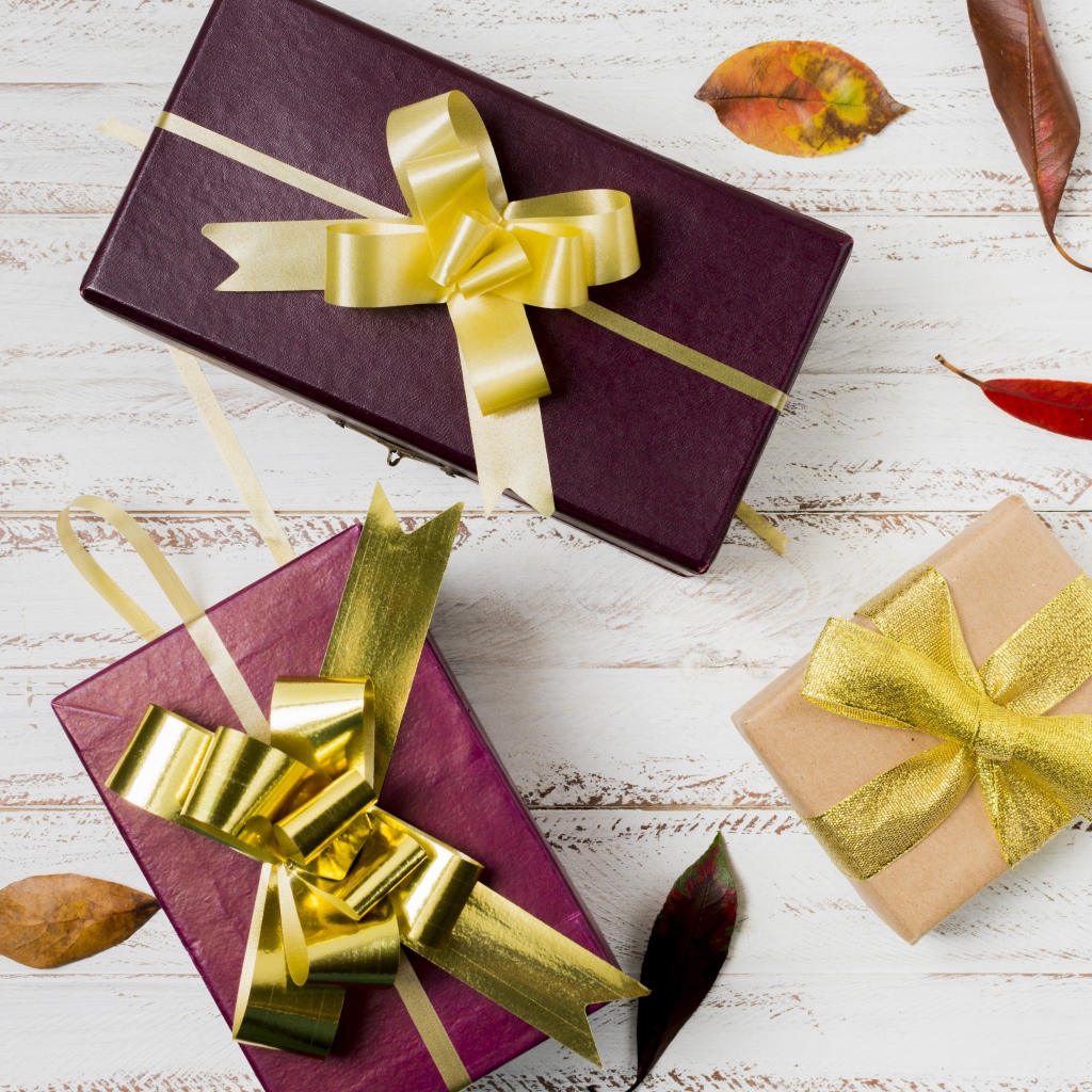 Три подарочные коробки с бантами на столе