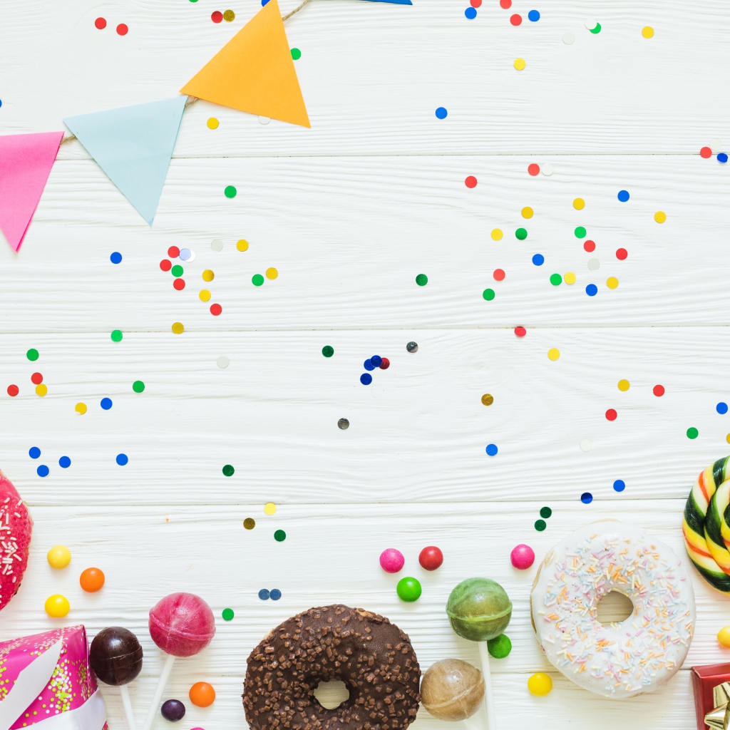 Пончики с глазурью и конфеты на праздничном фоне