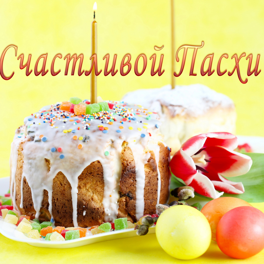 Красивый кулич с глазурью и зажженной свечой на праздник Счастливой Пасхи 