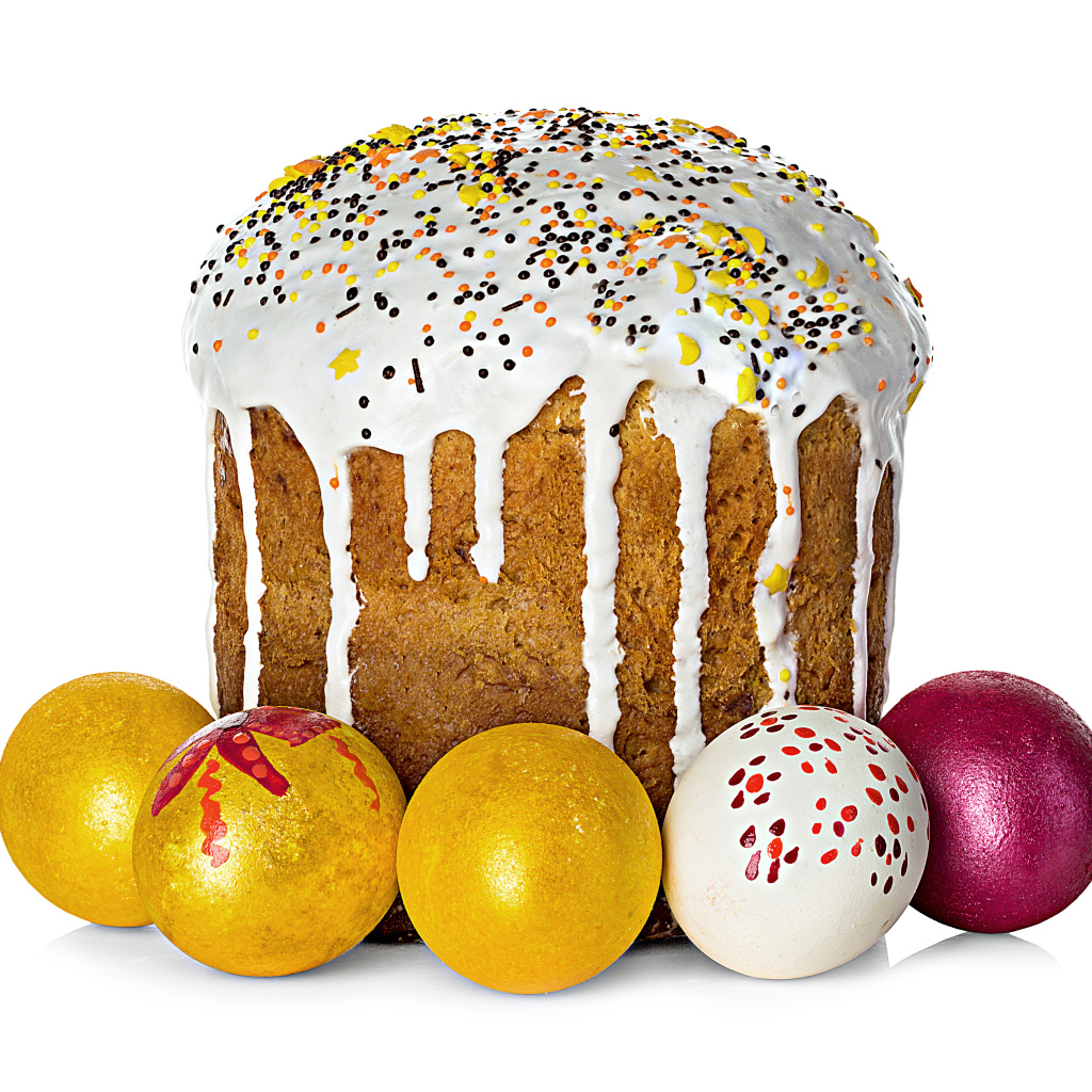 Красивый большой кулич с крашеными яйцами на белом фоне на Пасху