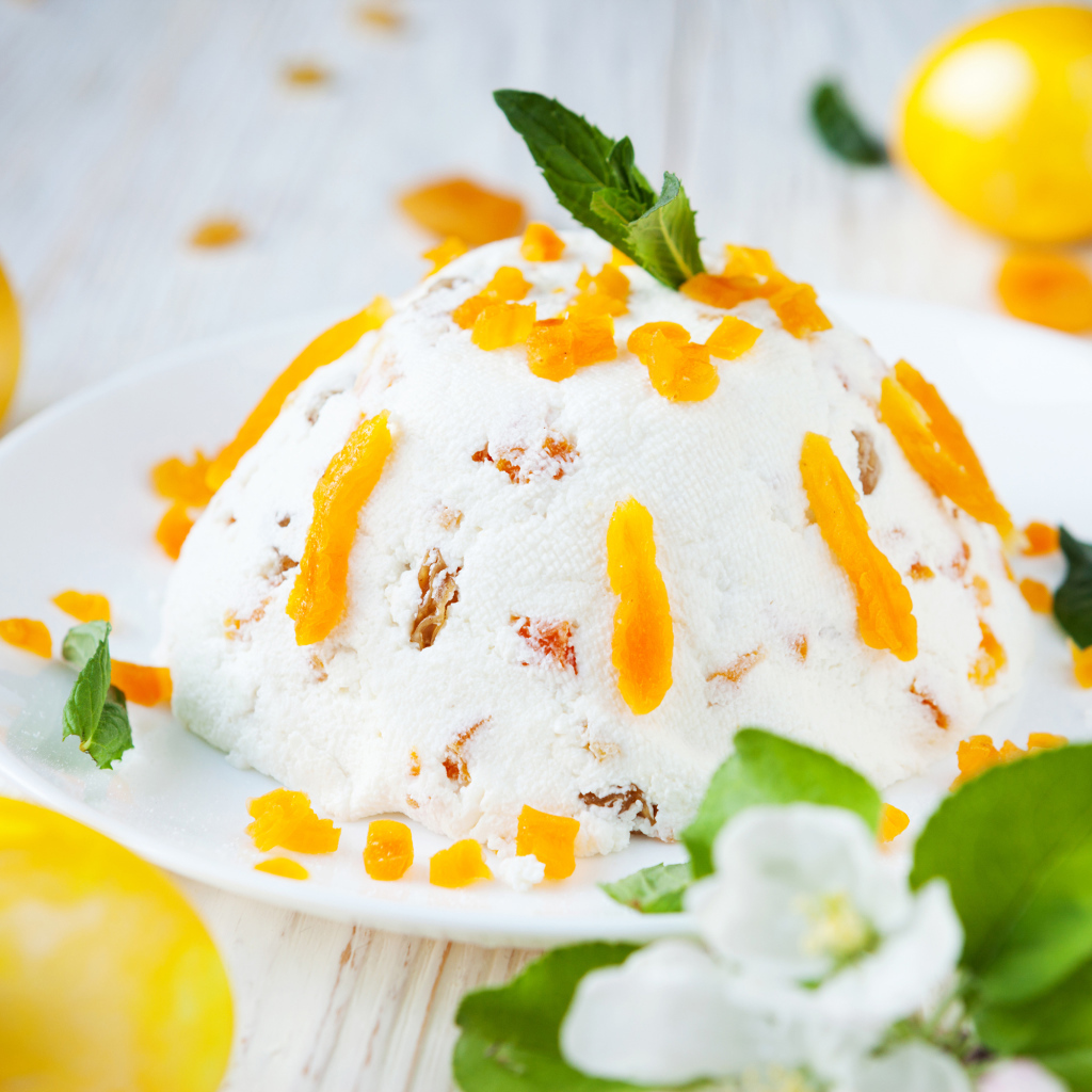 Сладкая творожная пасха с курагой на столе с крашеными яйцами