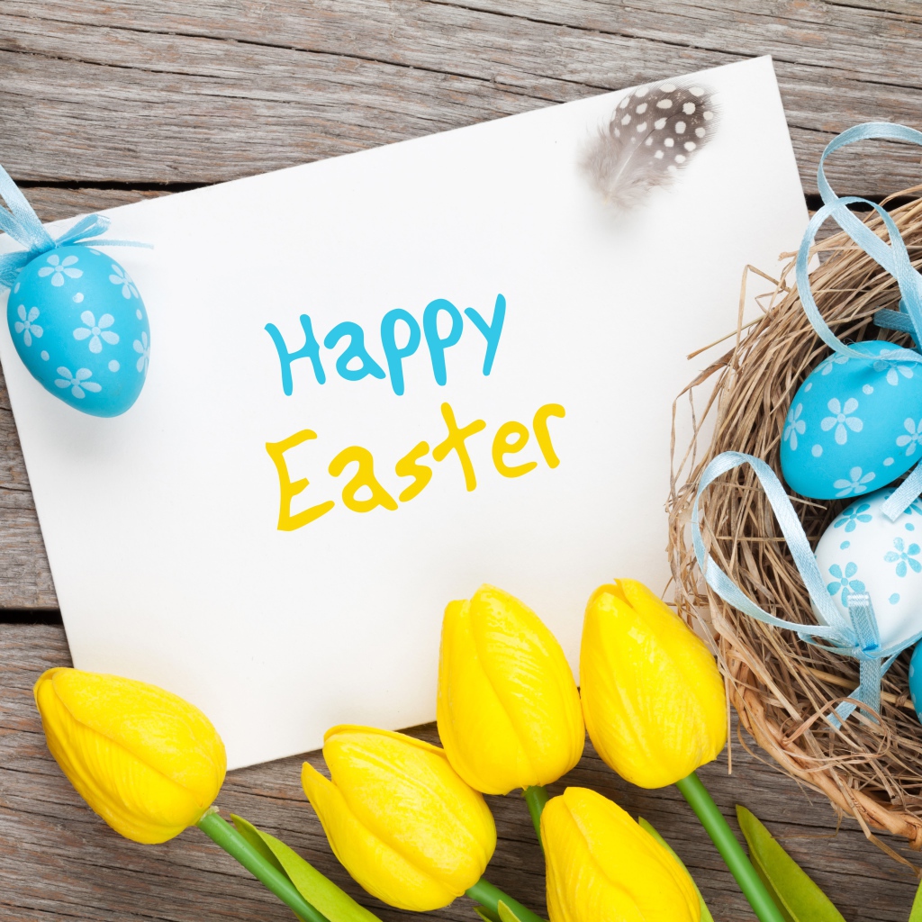 Надпись на белом листе Happy Easter с букетом желтых тюльпанов и крашенными яйцами