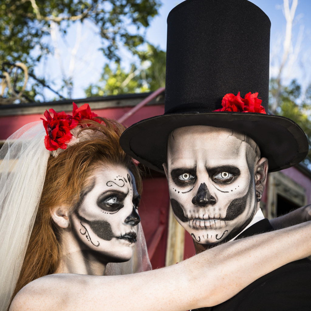 Пара жених и невеста с масками с грима на лице на Хэллоуин 