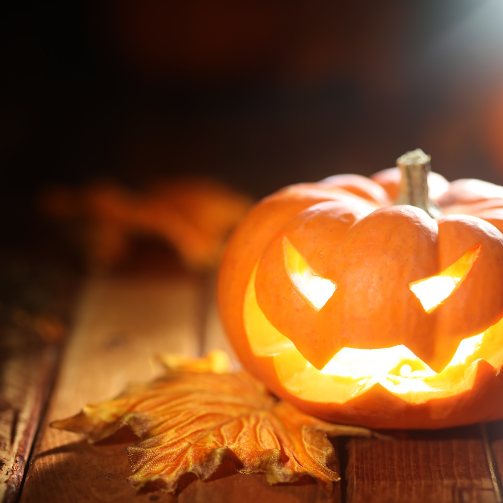 Светящаяся тыква на столе на Хэллоуин
