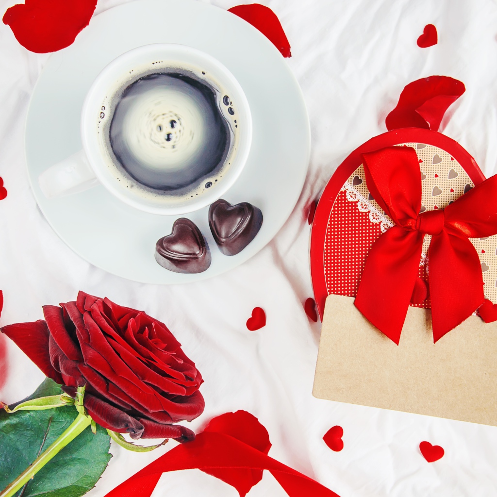 Чашка кофе на столе с коробкой в форме сердца и красной розой для любимой