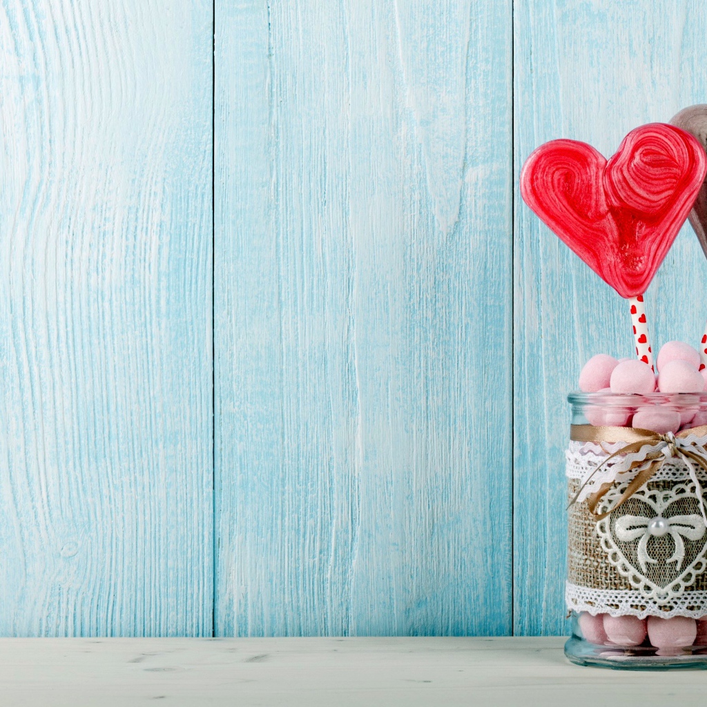 Банка с маршмеллоу и сердечками на голубом фоне