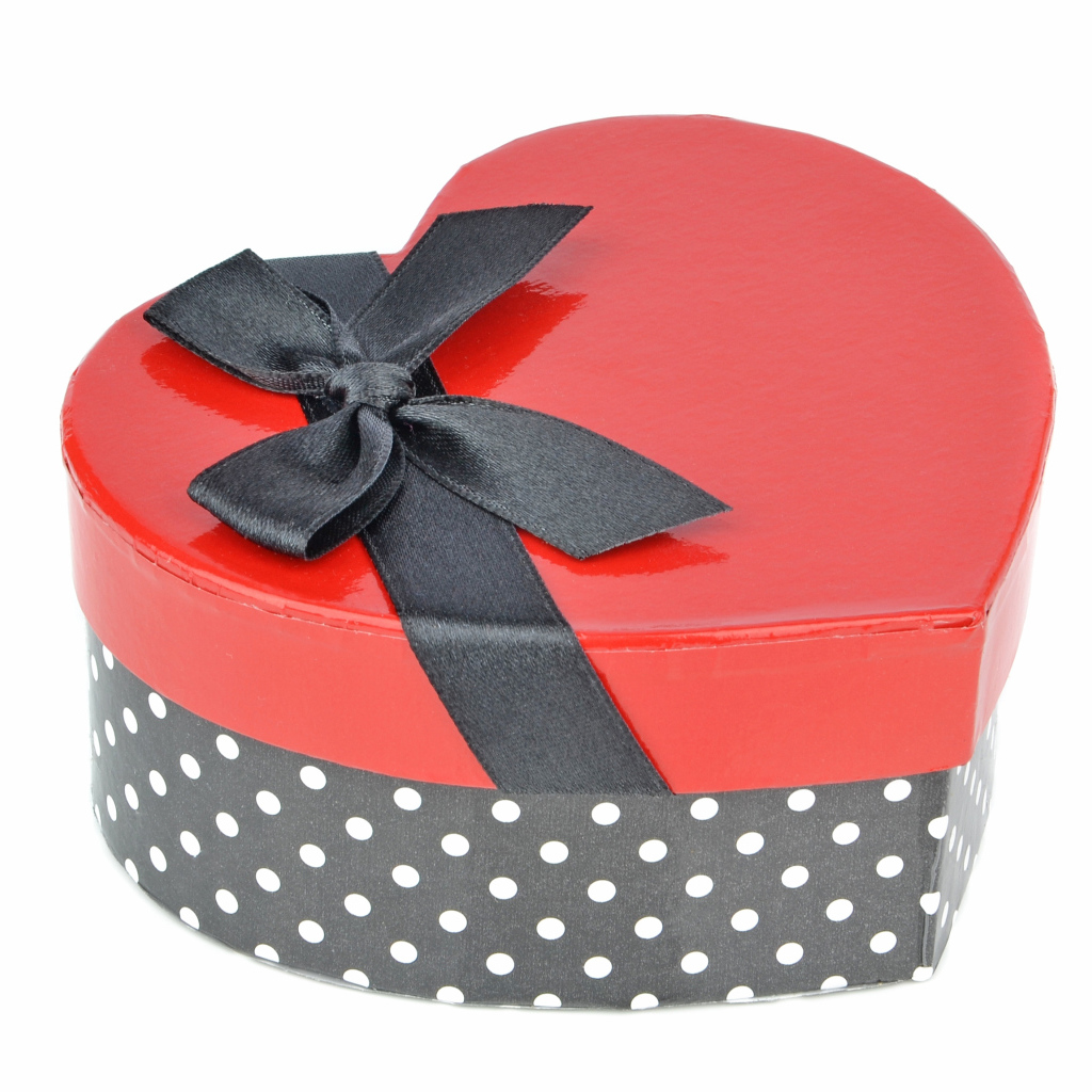 Красивая коробка в форме сердца с черным бантом на белом фоне