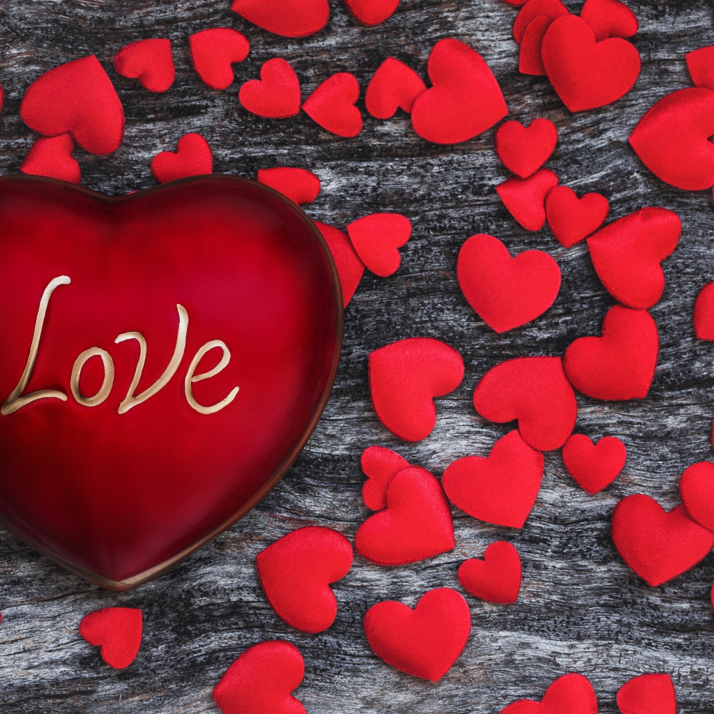 Большое красное сердце на деревянном фоне с маленькими сердечками