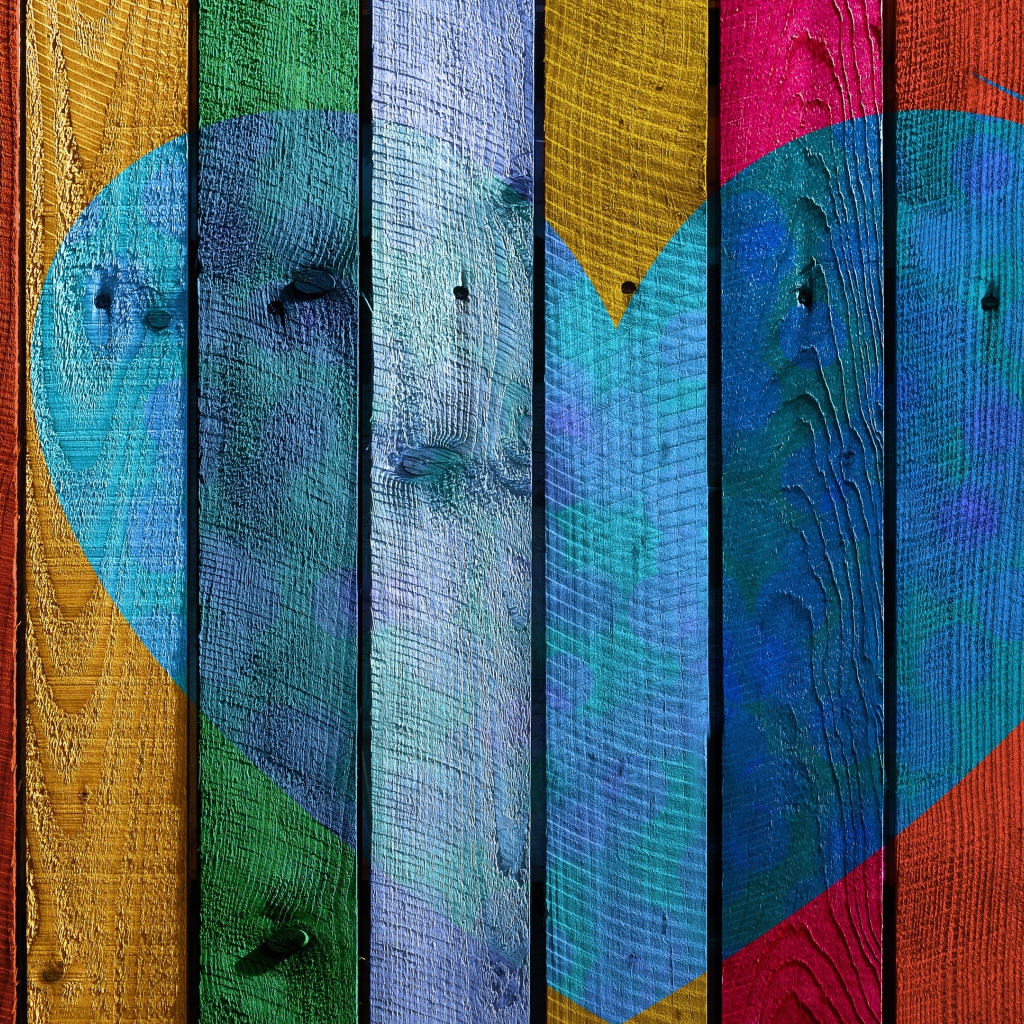 Голубое сердце нарисовано на разноцветном заборе