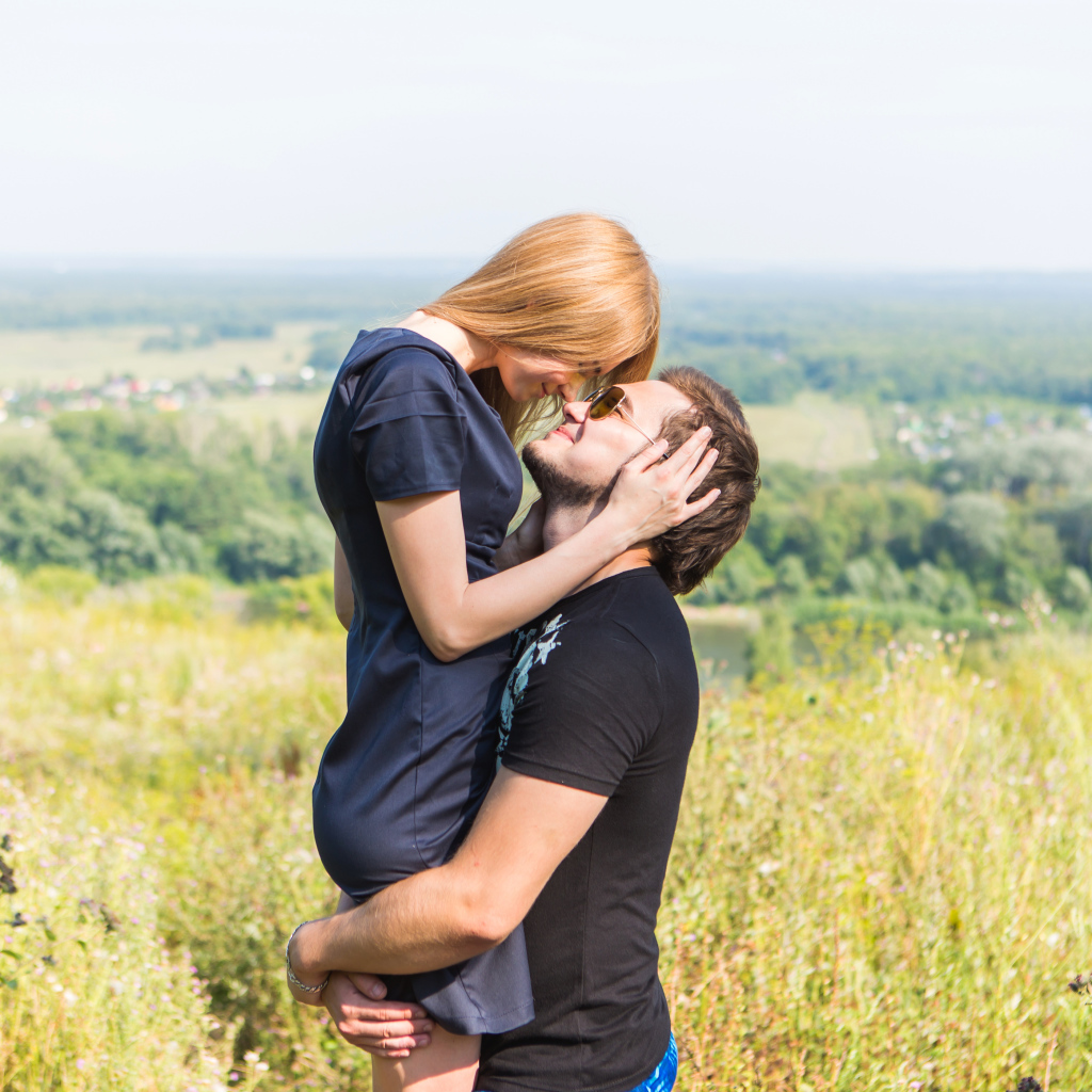 Влюбленная пара обнимается на поле 