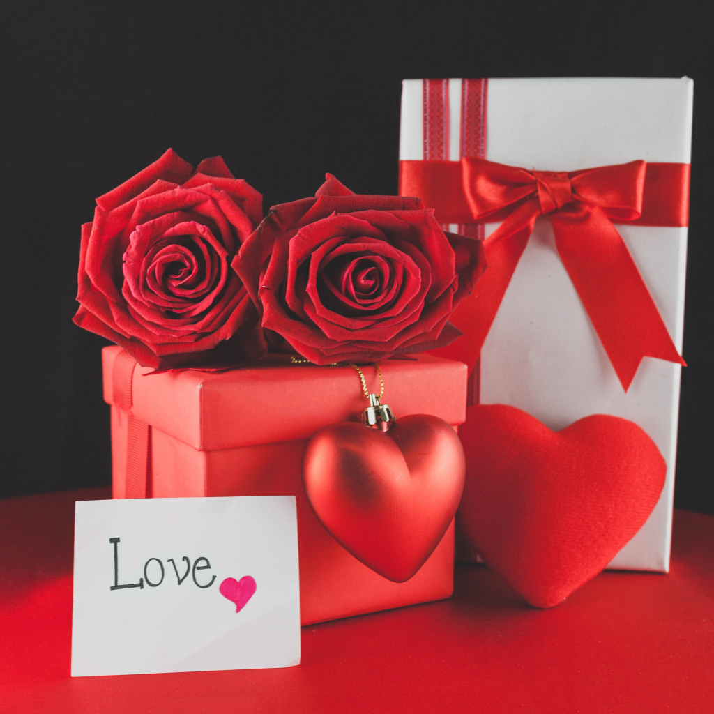Коробки с подарками на столе с красными розами и сердцем