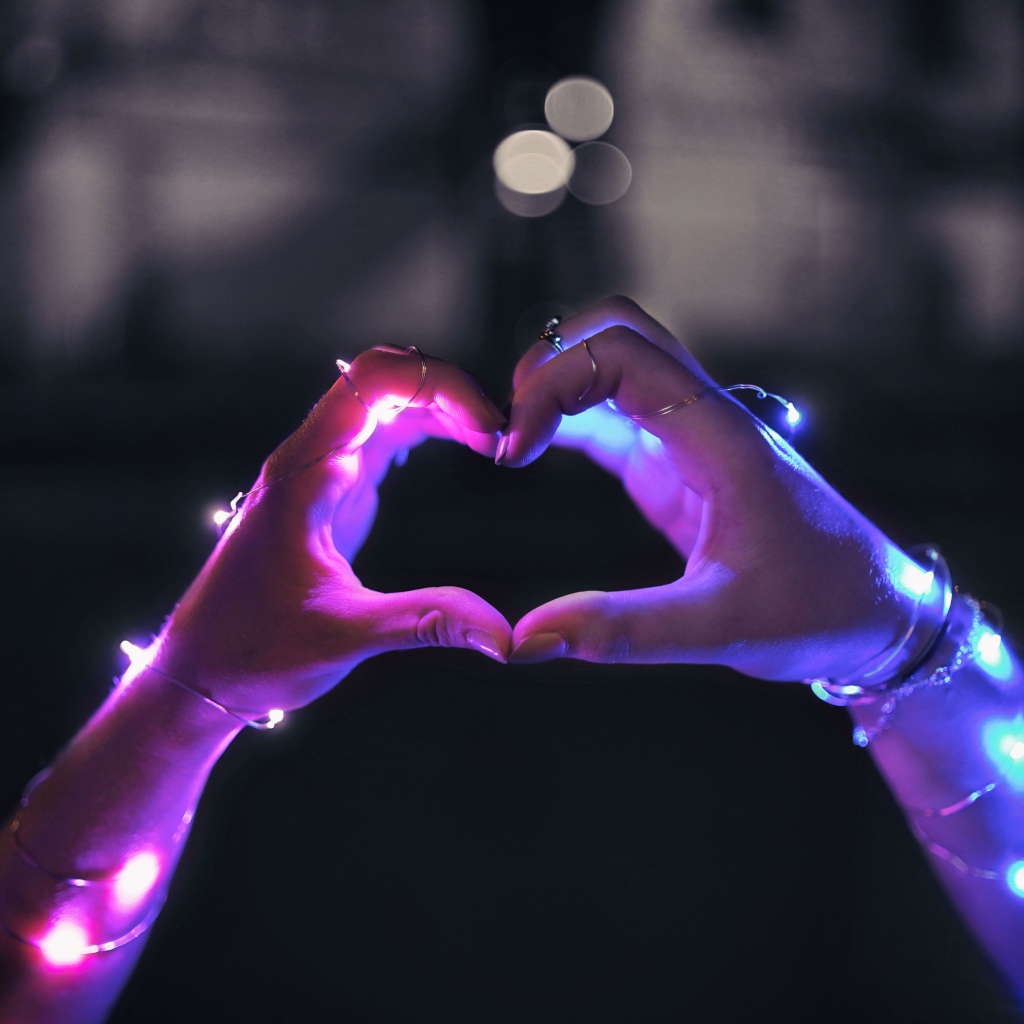 Девушка делает сердце руками