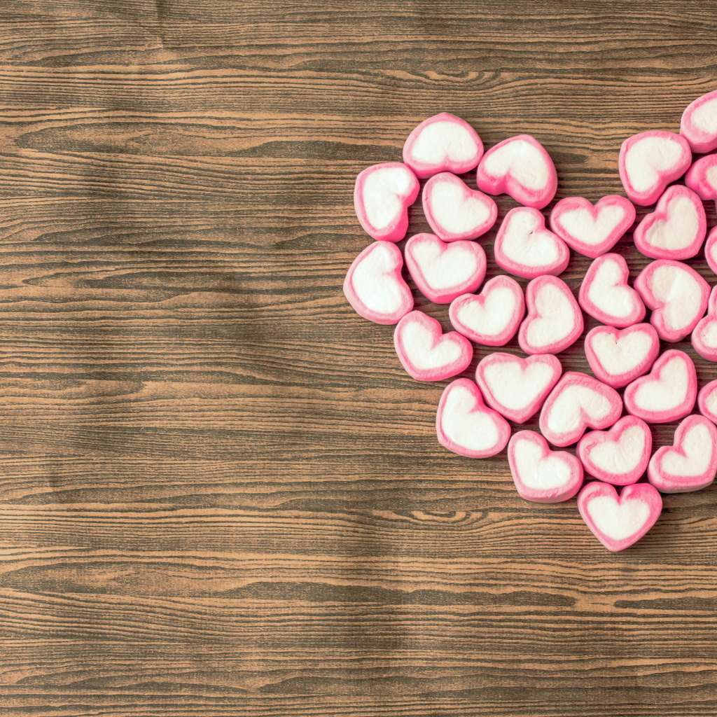 Сердце из конфет на деревянном столе