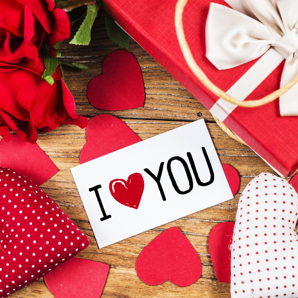 Сердечки, цветы и подарок на столе с запиской