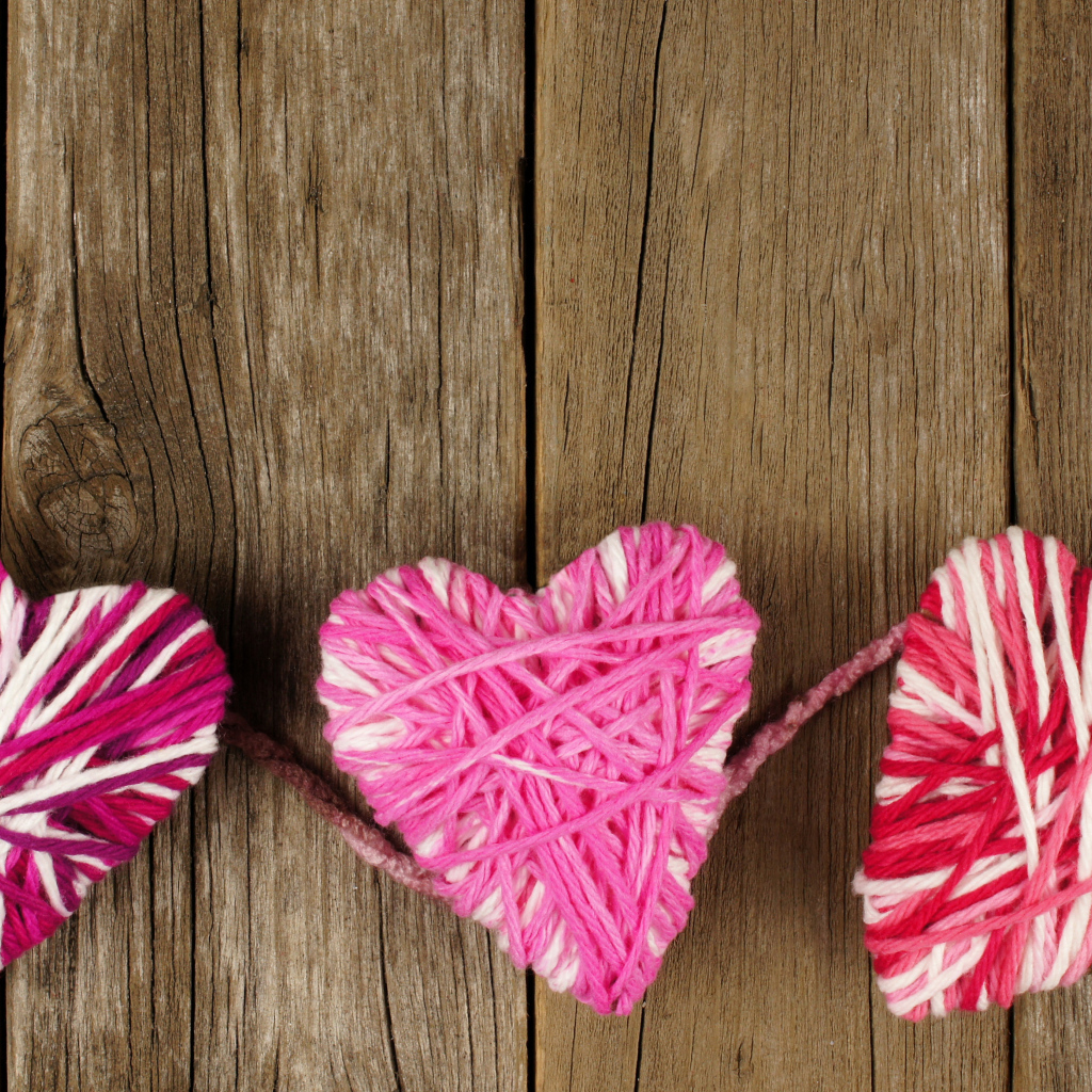 Сердца из ниток на деревянном столе