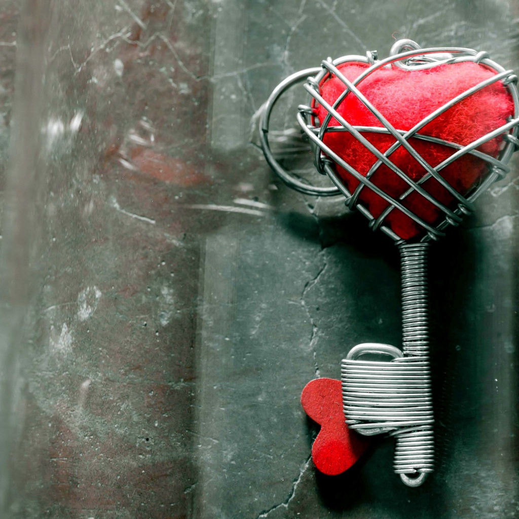 Ключ с красным сердцем на сером столе