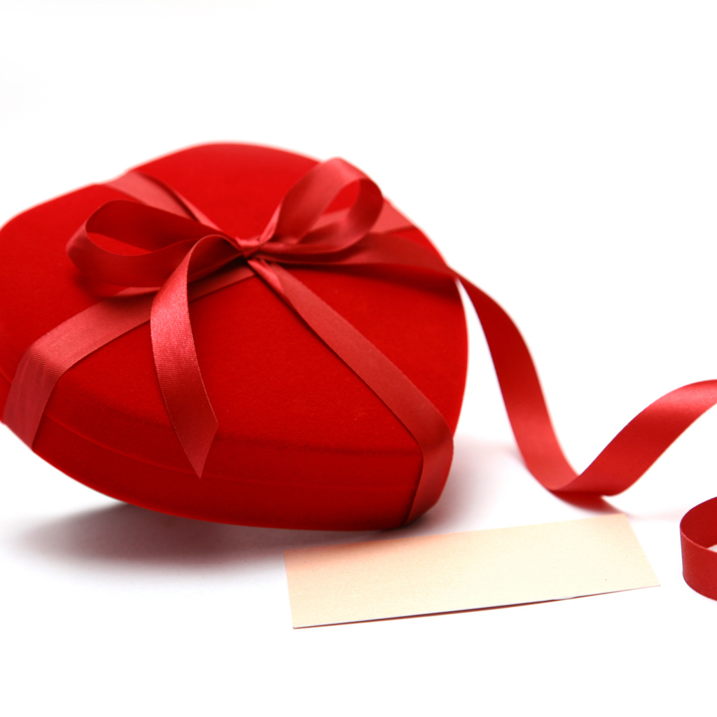 Красная коробка для ювелирных изделий в форме сердца на белом фоне 