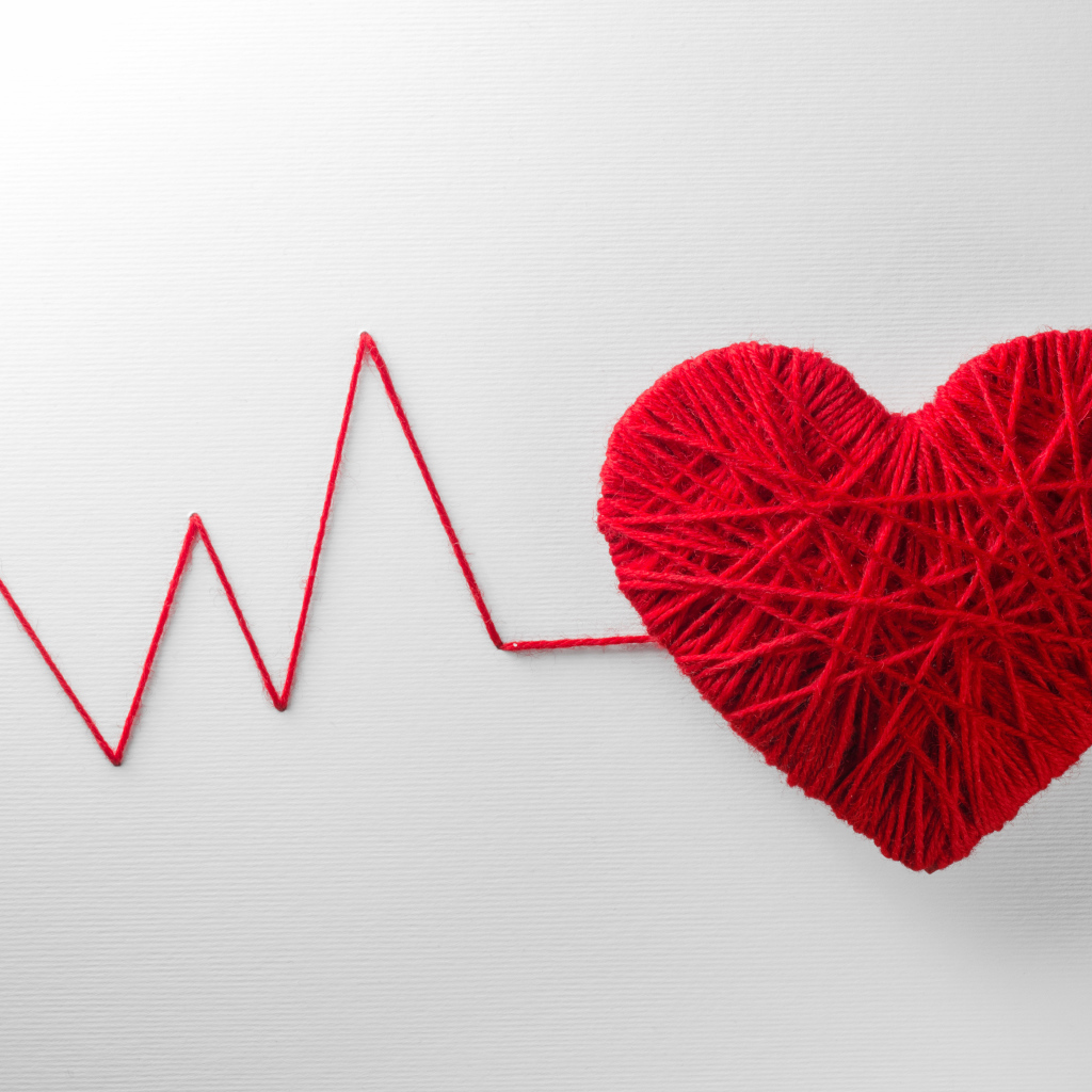 Красное сердце из нитей на сером фоне 