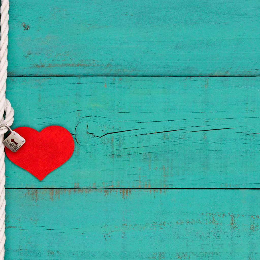 Красное сердечко на веревке с замком на голубом фоне