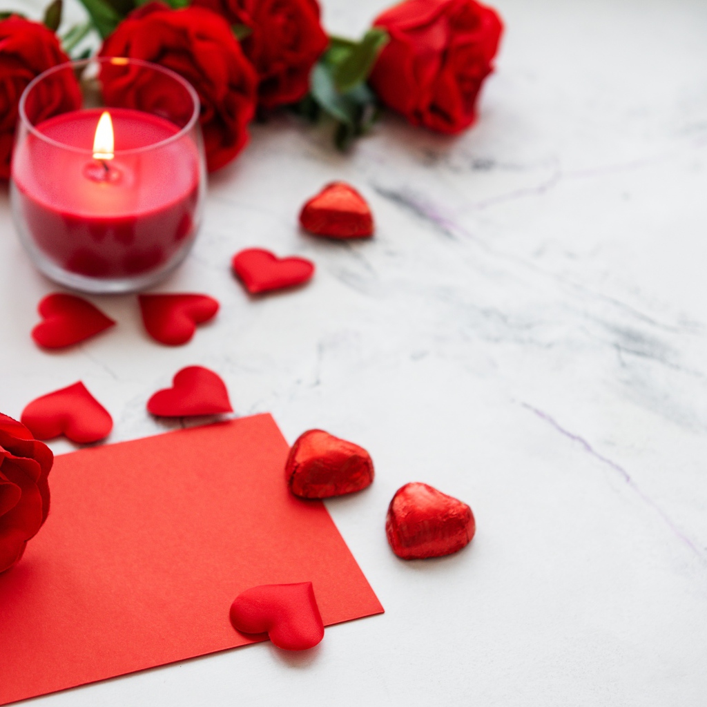 Красные сердечки, зажженная свеча и розы для любимой
