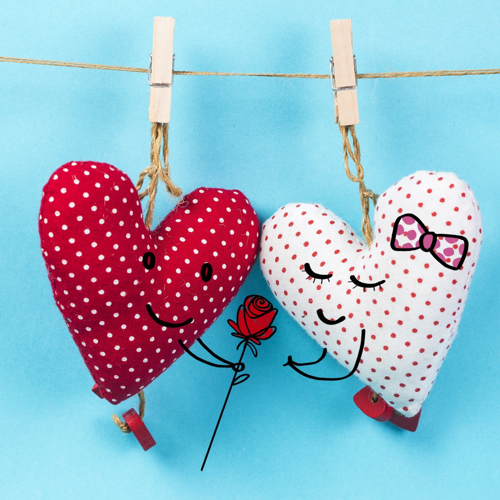 Два сердечка на прищепках на веревке на голубом фоне