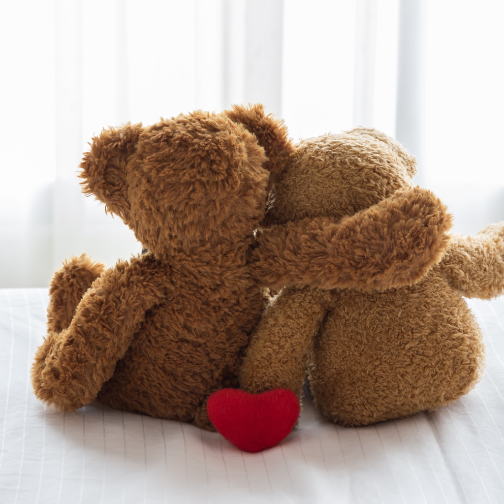 Два влюбленных плюшевых медвежонка на кровати