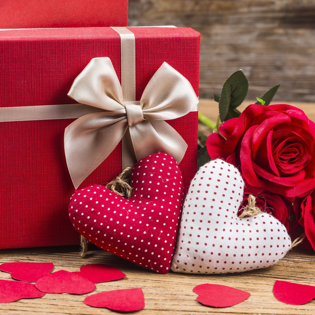 Два мягких сердечка на столе с подарком и розами для любимой