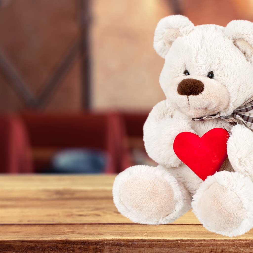 Белый плюшевый мишка с красным сердцем