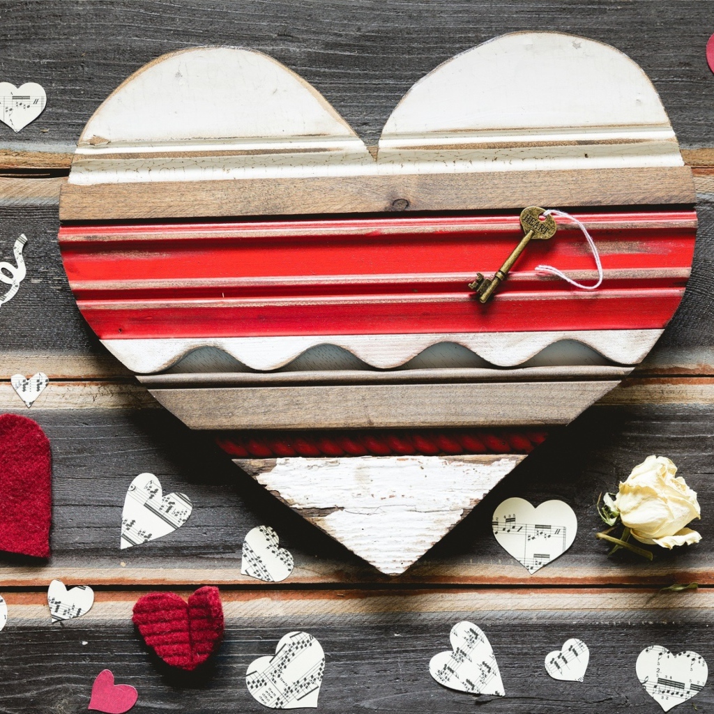 Деревянное сердце с бумажными сердечками на столе