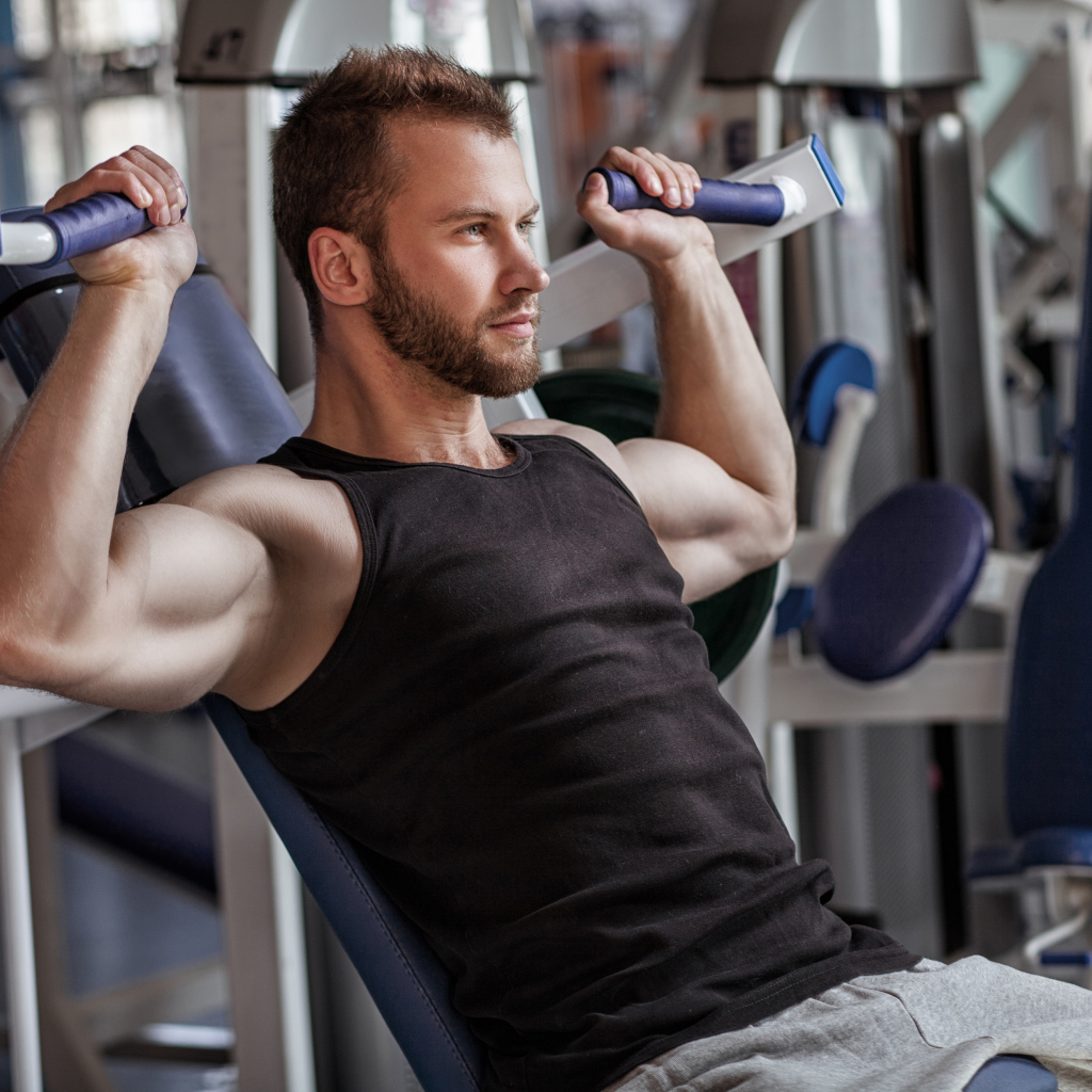 Накаченный мужчина занимается в спортзале