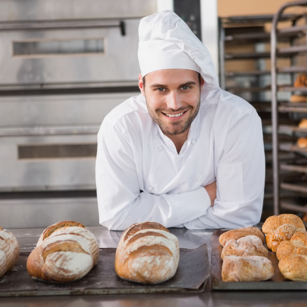 Красивый улыбающийся мужчина пекарь в форме