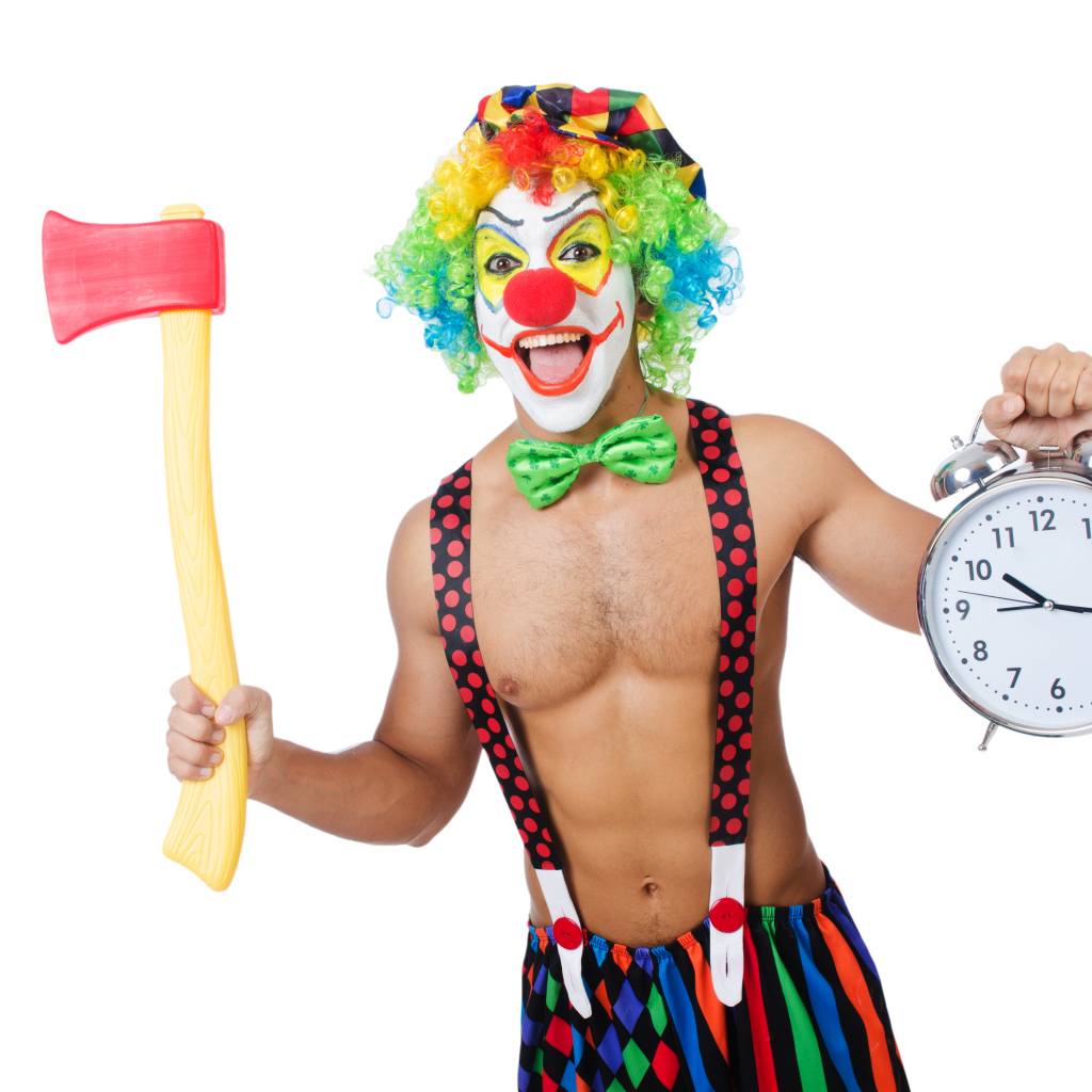 Мужчина  в костюме клоуна с топором и часами в руке на белом фоне