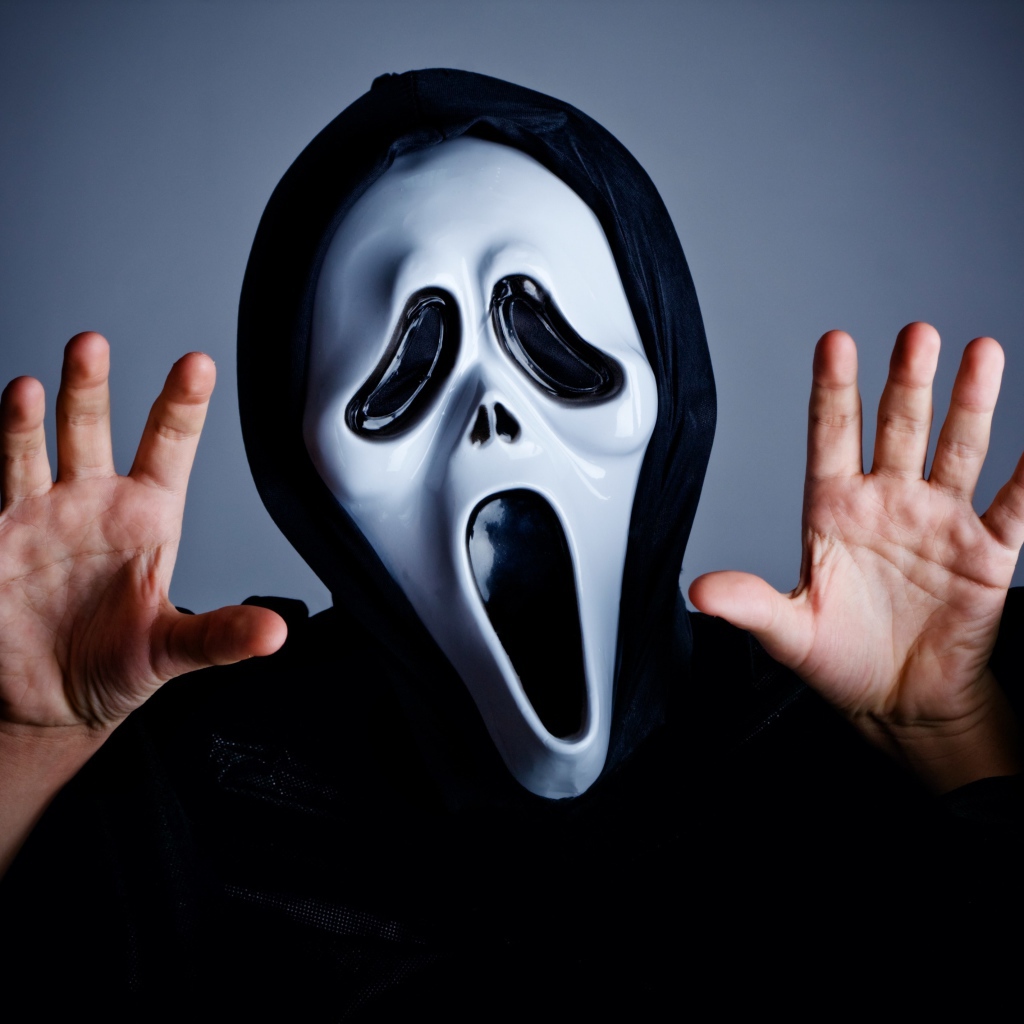 Man in mask scares on gray background