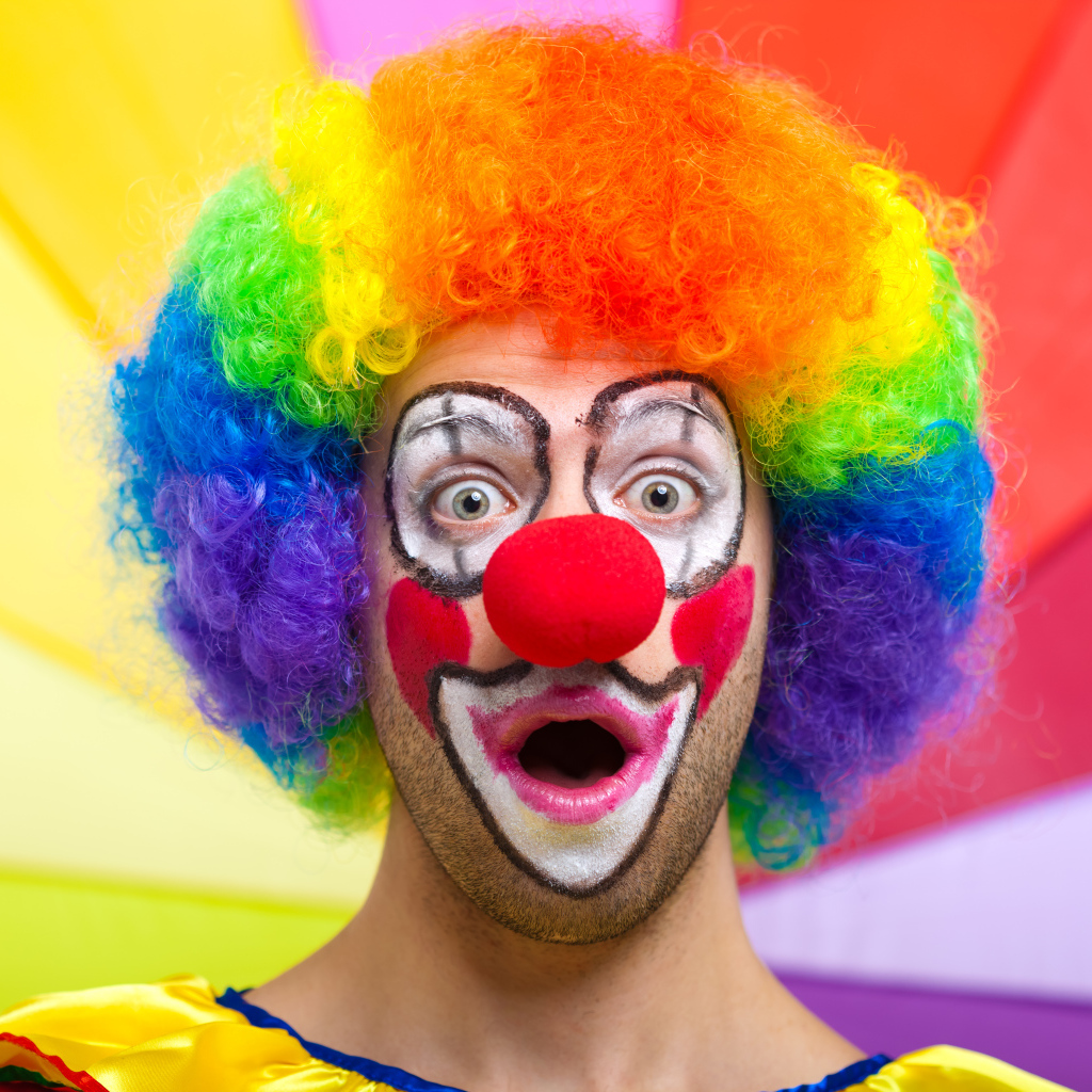 Удивленный мужчина в костюме клоуна 