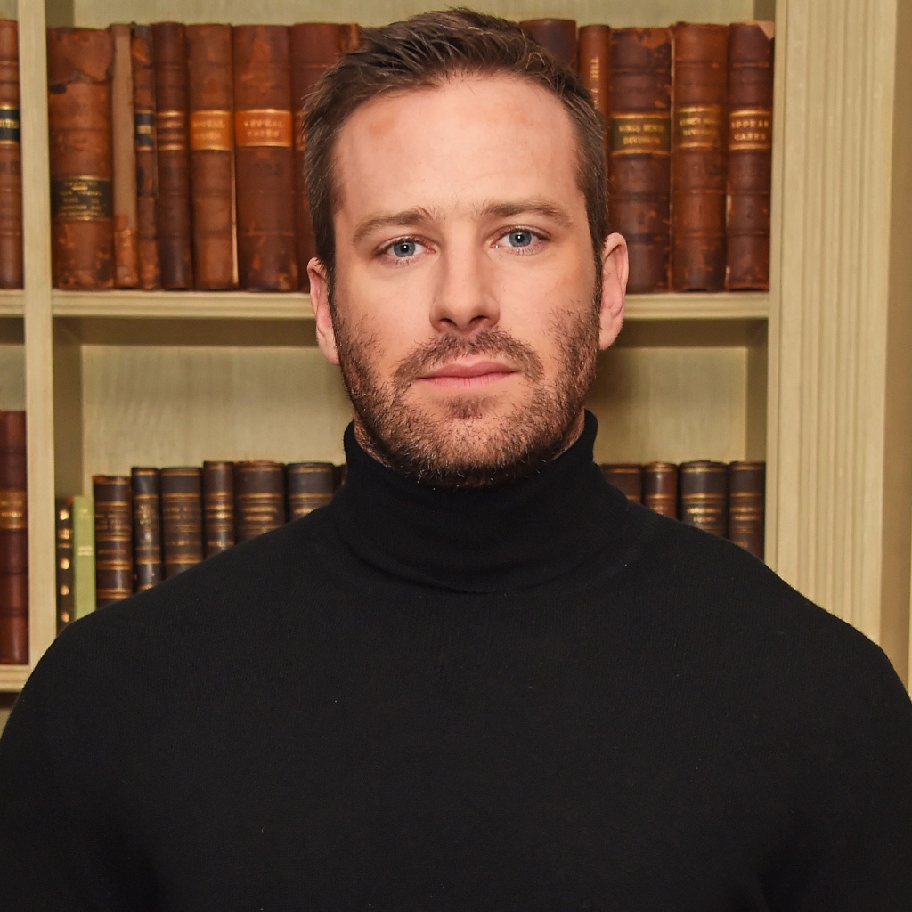 Актер Арми Хаммер стоит у библиотеки