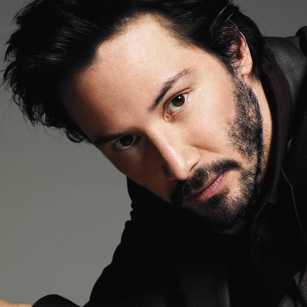 Актер Киану Ривз в костюме на сером фоне