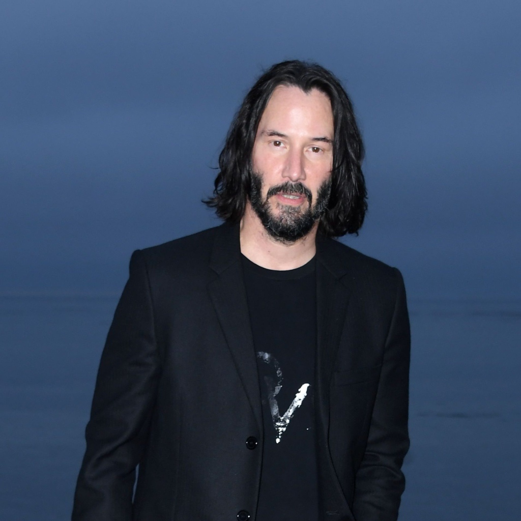 Актер Киану Ривз с бородой на синем фоне